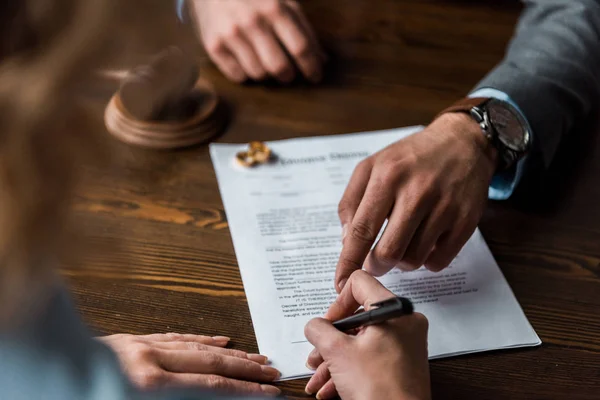 stock photo partial view judge pointing papers client signing divorce decree