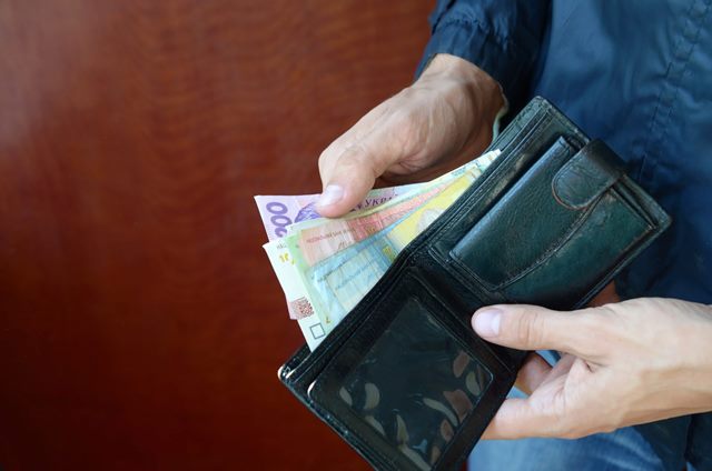 close up male hands opened the wallet or purse wit RPBNFZR min scaled